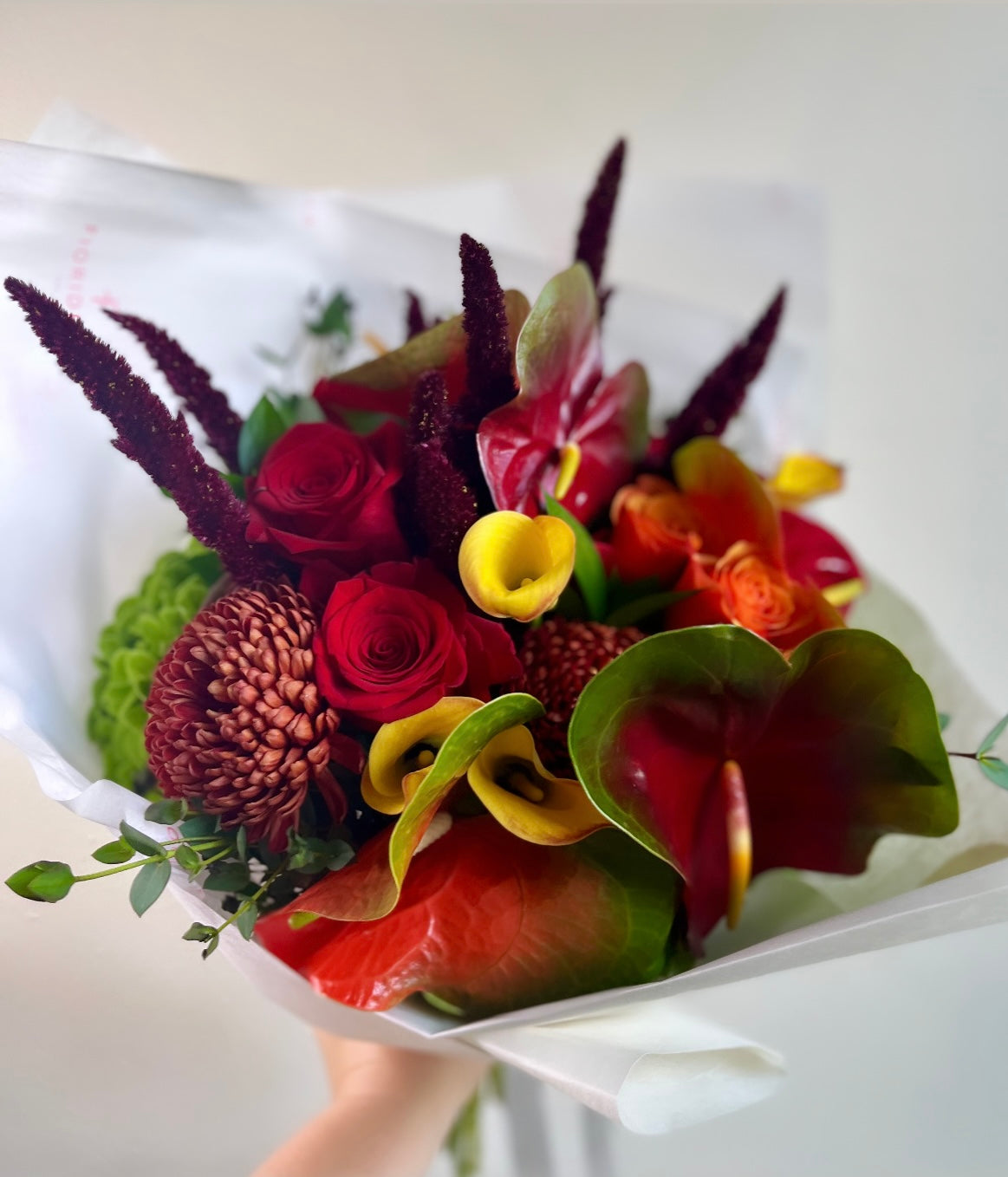 Autumn seasonal flowers hand-tied bouquet with red roses, anthuriums, yellow calla lilies and burgundy amaranth, Standard size