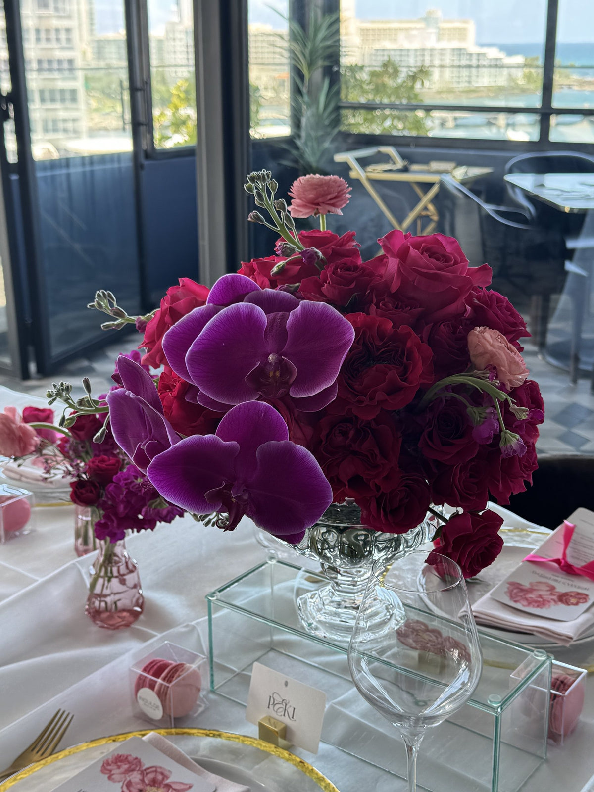 Close-up of purple phalaenopsis and red roses in a crystal vase