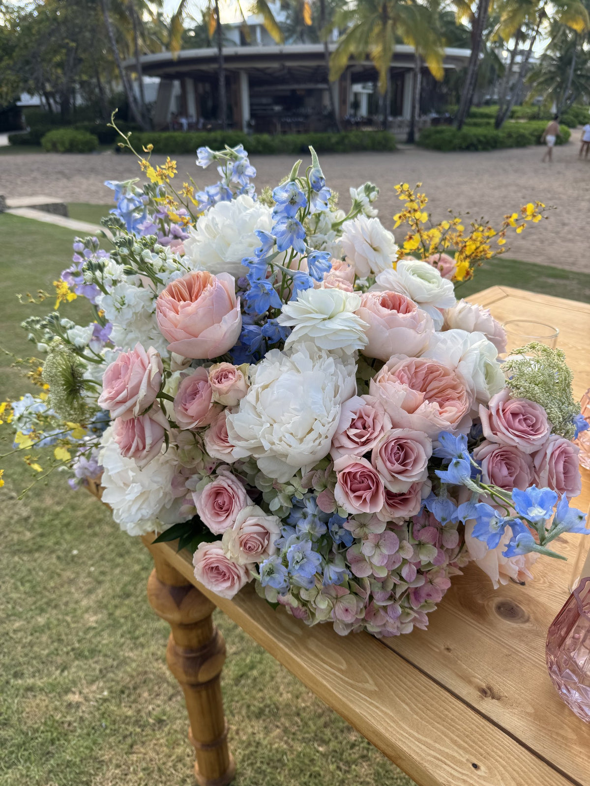 Close-up of garden roses, ranunculus, blue delphinium and yellow oncidium