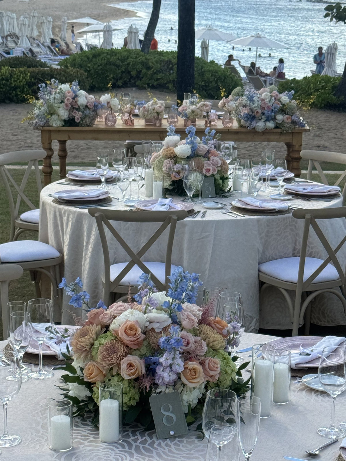 Reception tables with low pastel centerpieces facing the sea in Dorado