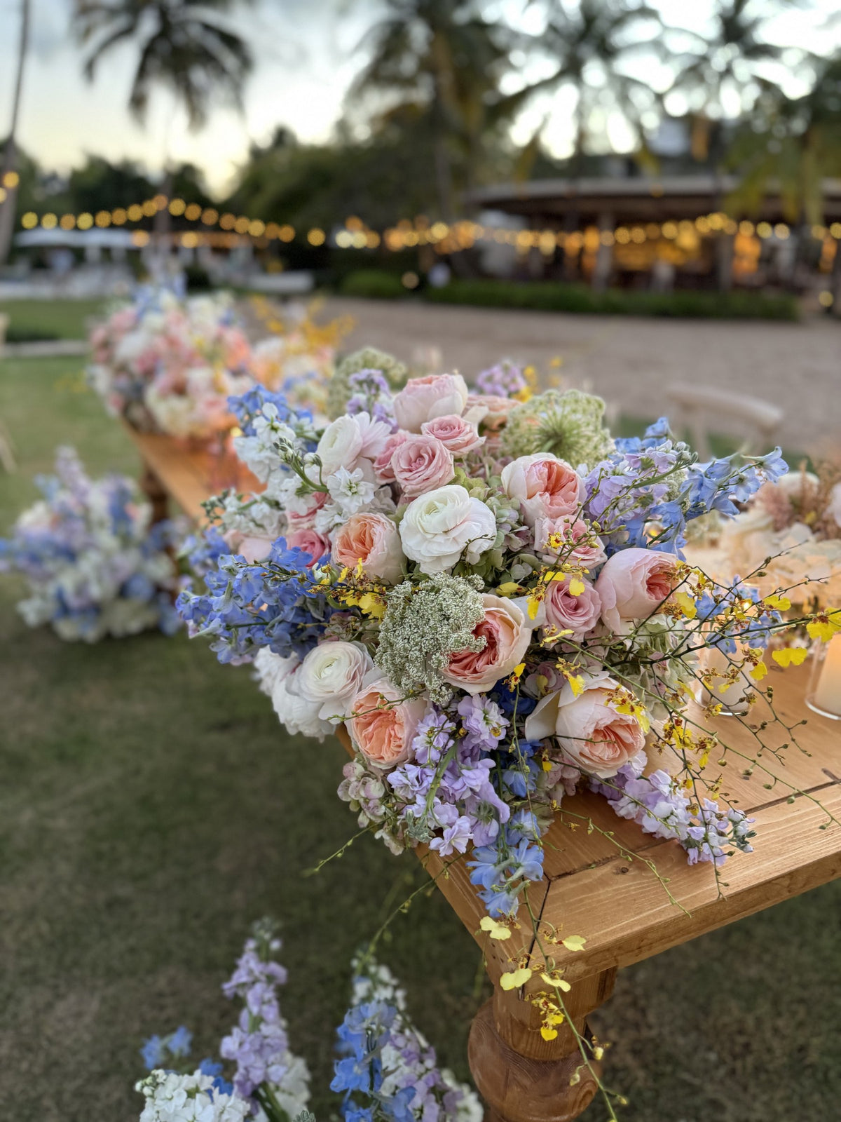 Corner of the head table with cascading pastel flowers and yellow orchids