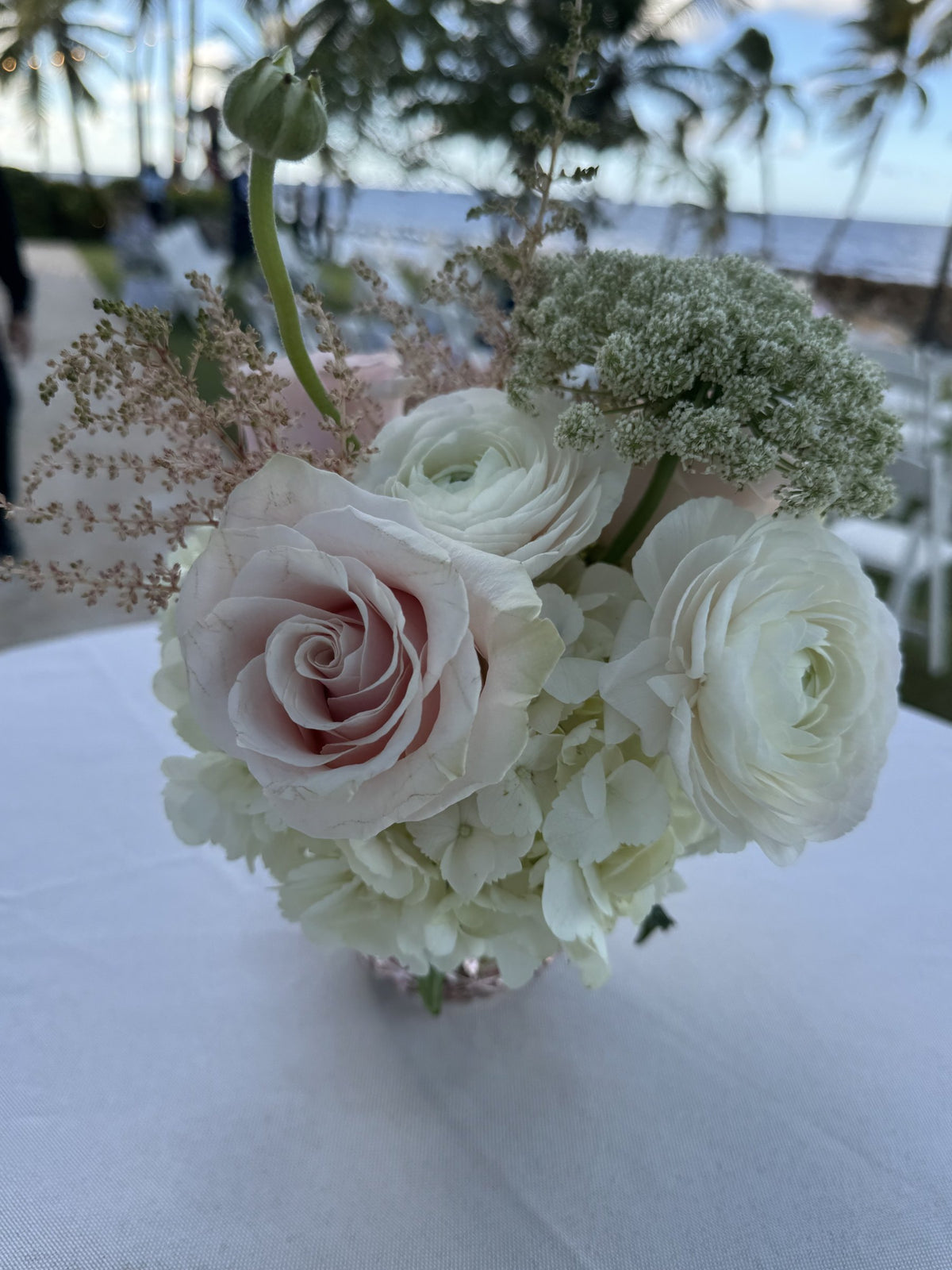 Low centerpiece of blush roses, white ranunculus and Queen Anne's lace
