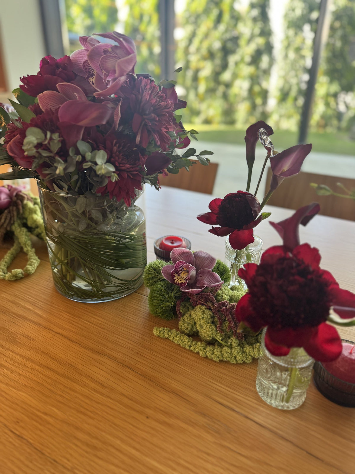 Burgundy arrangement in a glass vase with peonies, calla lilies and amaranth